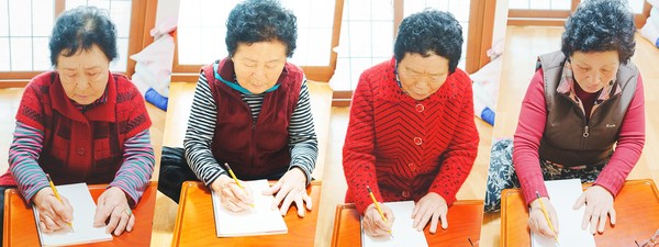 학교에서 배운 한글로 이름을 쓰고 있는 노복례·김순덕·박향임·이선숙 할머니들 모습. 
